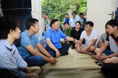 Bí thư Thành ủy Đinh Tiến Dũng động viên bà con cố gắng vượt qua khó khăn. (Ảnh: TTXVN phát)