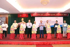 Ông Trương Hòa Bình - nguyên Ủy viên Bộ Chính trị, nguyên Phó Thủ tướng Thường trực Chính phủ và ông Nguyễn Hồ Hải - Phó Bí thư Thành ủy Thành phố Hồ Chí Minh trao tặng quà chúc mừng Ban Đại diện Cộng đồng Hồi giáo thành phố. (Ảnh: Xuân Khu/TTXVN)