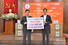 Ông Nguyễn Văn Long - đại diện Cục Thú y (trái) tiếp nhận 5.000 kit xét nghiệm nhanh Salbutamol do Công ty Cổ phần Chăn nuôi C.P. Việt Nam hỗ trợ. (Ảnh: Phạm Hiếu)