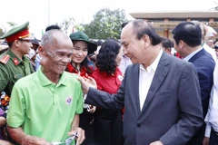 Chủ tịch nước Nguyễn Xuân Phúc với các đối tượng chính sách huyện Hòn Đất. (Ảnh: Thống Nhất/TTXVN)