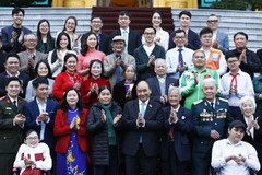 Chủ tịch nước Nguyễn Xuân Phúc với các nhân vật trong chương trình Việc tử tế của Đài Truyền hình Việt Nam trong năm 2022. (Ảnh: Thống Nhất/TTXVN)