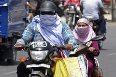 Người đi đường trùm khăn tránh nắng nóng ở Amritsar (Ấn Độ). (Ảnh: AFP/TTXVN)