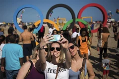 Khách du lịch chụp ảnh tại một bãi biển ở Rio de Janeiro trong dịp Olympic. (Nguồn: Xinhua)
