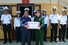 Đoàn công tác trao quà cho cán bộ trạm hải đăng đảo Đá Lát. (Ảnh: Tiến Đạt/Vietnam+) 
