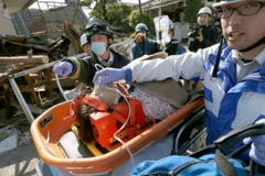 Một phụ nữ được lực lượng cứu hộ đưa ra khỏi đống đổ nát sau trận động đất ở Mashiki, tỉnh Kumamoto ngày 16/4. (Nguồn: AFP/TTXVN) 