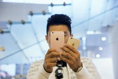 Một người đàn ôngtử chụp ảnh với hai mẫu iPhone 6s và 6s Plus trong một cửa hàng Apple Store ở Bắc Kinh.(Nguồn: gadgetsmade.com)