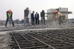 Các lực lượng thi công tiến hành phá dỡ phần vi phạm tại tầng 19 tòa tòa nhà 8B Lê Trực. (Ảnh: Nguyễn Văn Cảnh/TTXVN)