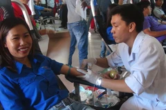 Các đoàn viên thanh niên, cán bộ, công nhân viên chức tham gia hiến máu tình nguyện tại chương trình. (Ảnh: Trịnh Bang Nhiệm/TTXVN)