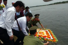 Phó Thủ tướng Vương Đình Huệ thả hoa xuống bờ Bắc sông Thạch Hãn để tưởng nhớ công lao các Anh hùng, liệt sỹ. (Ảnh: Trịnh Bang Nhiệm/TTXVN) 