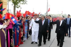 Tổng Bí thư Nguyễn Phú Trọng và Tổng Bí thư, Chủ tịch nước Lào Bounnhang Volachith vẫy chào nhân dân thủ đô Hà Nội. (Ảnh: Trí Dũng/TTXVN)