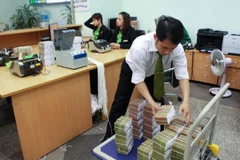 Cán bộ Vietcombank đang sắp xếp tiền để nạp cho cây ATM. (Nguồn: Vietcombank)