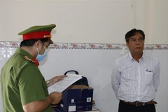 Nguyễn Ngọc Thanh Hải nghe Cơ quan Cảnh sát Điều tra tống đạt các quyết định. (Ảnh: TTXVN phát)