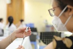 Cán bộ, công chức, viên chức và người lao động hưởng ứng tiêm vaccine mũi nhắc lại trong ngày phát động. (Ảnh: Minh Quyết/TTXVN)