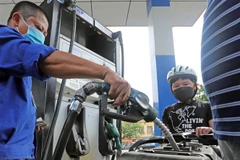 Mua bán xăng dầu tại điểm kinh doanh xăng, dầu của Petrolimex. (Ảnh: Trần Việt/TTXVN)