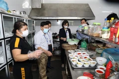 Đoàn công tác kiểm tra khu vực chế biến đồ ăn của một nhà hàng. (Ảnh: Đức Phương/TTXVN)