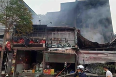 Hiện trường vụ cháy tại địa chỉ ở số 63 Nguyễn Hoàng lan ra nhiều nhà xung quanh. (Ảnh: TTXVN phát)