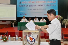 Các thành viên Hội đồng chung khảo bỏ phiếu chấm Giải Báo chí Quốc gia lần thứ IX. (Ảnh: Minh Quyết/TTXVN)