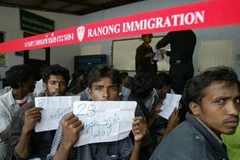 Những người Rohingya ngồi trước đồn cảnh sát trước khi bị đưa đến trung tâm tị nạn. (Nguồn: AFP)