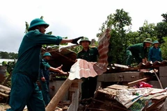 Lợp lại mái nhà giúp dân. (Ảnh minh họa: Nguyễn Dũng/TTXVN)