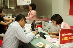 Khách giao dịch mua vàng tại hội sở Techcombank Hà Nội. (Ảnh: Trần Việt/TTXVN)