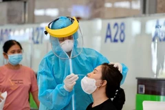 Lấy mẫu xét nghiệm COVID-19 nhanh với hành khách bay nội địa. (Ảnh: CTV/Vietnam+)