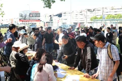 Các chủ quầy hàng bị thiệt hại trong vụ cháy TTTM Marywilska tập trung làm thủ tục nhận tiền hỗ trợ. (Ảnh: Ngọc Biên/TTXVN)