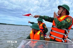 Bộ đội biên phòng hỗ trợ nhân dân ứng phó áp thấp nhiệt đới. (Nguồn: TTXVN)