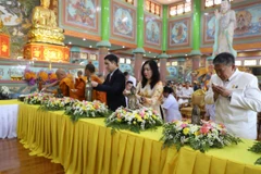 Thứ trưởng Ngoại giao Lê Thị Thu Hằng, Đại sứ Phạm Việt Hùng cùng các vị sư và Phật tử thực hiện nghi thức tắm tượng. (Ảnh: Đỗ Sinh/TTXVN)