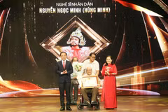 Bí thư Thành ủy Thành phố Hồ Chí Minh Nguyễn Văn Nên trao danh hiệu tôn vinh Nghệ sỹ Nhân dân Hùng Minh. (Ảnh: Thu Hương/TTXVN)