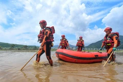 Lực lượng cứu hộ làm nhiệm vụ tại khu vực ngập lụt ở tỉnh Cát Lâm, Trung Quốc ngày 29/7. (Ảnh: THX/TTXVN)