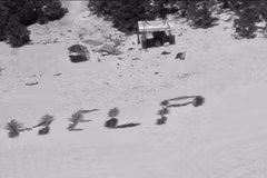 Các ngư dân nhặt lá cọ trên đảo, xếp thành từ “HELP.” (Nguồn: CNN)