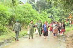 Lực lượng chức năng hỗ trợ người dân huyện Mường Lát (Thanh Hóa) sơ tán đến nơi an toàn. (Ảnh: TTXVN phát)