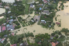 Tuyến đường từ xã Nhuận Trạch đi xã Thủy Xuân Tiên (huyện Chương Mỹ, Hà Nội) ra đường Hồ Chí Minh và khu dân cư ven đường bị ngập lụt nghiêm trọng. (Ảnh: Trọng Đạt/TTXVN)