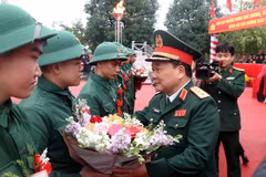 Thượng tướng Hoàng Xuân Chiến, Thứ trưởng Bộ Quốc phòng tặng hoa tân binh lên đường nhập ngũ tại huyện Kim Động, tỉnh Hưng Yên. (Ảnh: Đinh Văn Nhiều/TTXVN)