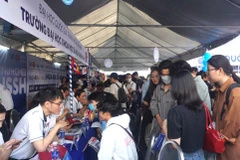 Thí sinh nghe tư vấn tại gian tư vấn của trường Đại học Khoa học Xã hội và Nhân văn, Đại học Quốc gia Thành phố Hồ Chí Minh. (Ảnh: Thu Hoài/TTXVN)