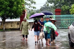 Cán bộ chính quyền địa phương hộ trợ người dân di dời trước nguy cơ sạt lở núi cây Sường (thị trấn Quy Đạt, huyện Minh Hóa). (Ảnh: Tá Chuyên/TTXVN)
