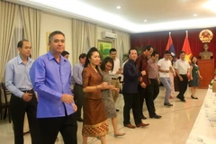 Cán bộ nhân viên Đại sứ quán hai nước tham gia tiết mục múa Lào. (Ảnh: Hoàng Nhương/Vietnam+)