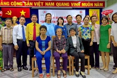 Đại diện các gia đình có người thân mất liên lạc được đoàn tụ chụp ảnh lưu niệm tại lễ kỷ niệm. (Ảnh: Thế Anh/TTXVN)