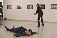 Kẻ tấn công (phía sau) và Đại sứ Nga Andrey Karlov (trước) sau vụ xả súng tại trung tâm nghệ thuật ở Ankara ngày 19/12. (Nguồn: AFP/TTXVN)