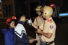 Lực lượng Cảnh sát giao thông kiểm tra nồng độ cồn chủ phương tiện. (Ảnh: Quang Duy/TTXVN)