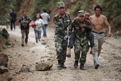 Đội cứu hộ đưa một cụ già bị thương thoát khỏi khu vực nguy hiểm sau một trận động đất tại Trung Quốc. (Nguồn: News.cn)