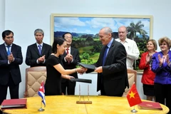 Đại diện công ty Davac của Việt Nam và Viện Vắcxin Finlay của Cuba trao đổi văn bản thỏa thuận về cùng phát triển vắcxin chống thương hàn. (Ảnh: Vũ Lê Hà/TTXVN)