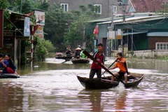 Người dân xã Cẩm Duệ dùng thuyền để đi lại sinh hoạt. (Ảnh Công Tường/TTXVN)