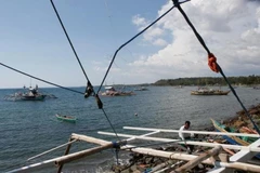 Một ngư dân sửa chữa thuyền tại bãi cạn Scarborough. (Nguồn: Reuters)