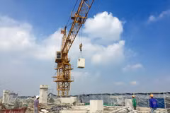 Vận chuyển bêtông từ tầng 19 tòa nhà 8B Lê Trực xuống mặt đất. (Ảnh: Minh Nghĩa/Vietnam+) 