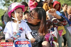 Phụ huynh động viên con mình thử thách với chiếc xe thăng bằng. 