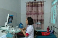 Bác sỹ trẻ Nguyễn Thị Thu Hồng khám chữa bệnh cho người dân. (Ảnh: PV/Vietnam+)