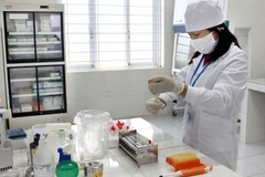 Nhân viên Trung tâm Phòng, chống HIV/AIDS thực hiện xét nghiệm máu, điều trị cho bệnh nhân. (Ảnh: Dương Ngọc/TTXVN)