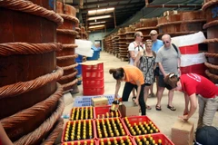 Du khách nước ngoài tham quan cơ sở sản xuất nước mắm đặc sản tại thị trấn An Thới, huyện Phú Quốc. (Ảnh: Đình Huệ/TTXVN)