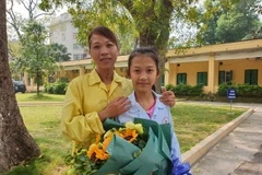 Hai mẹ con bé Trần Ngọc Diệu vui mừng khi đã chiến thắng bệnh lao màng não. (Ảnh: PV/Vietnam+)